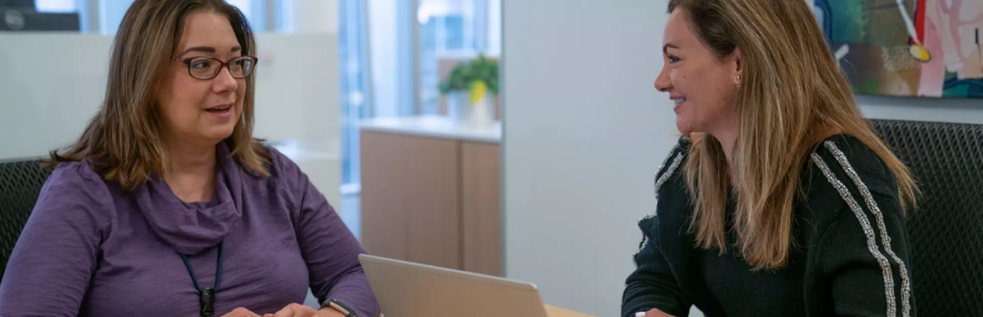 The Program lead of ‘Ensemble’ sitting with a Novartis employee and caregiver