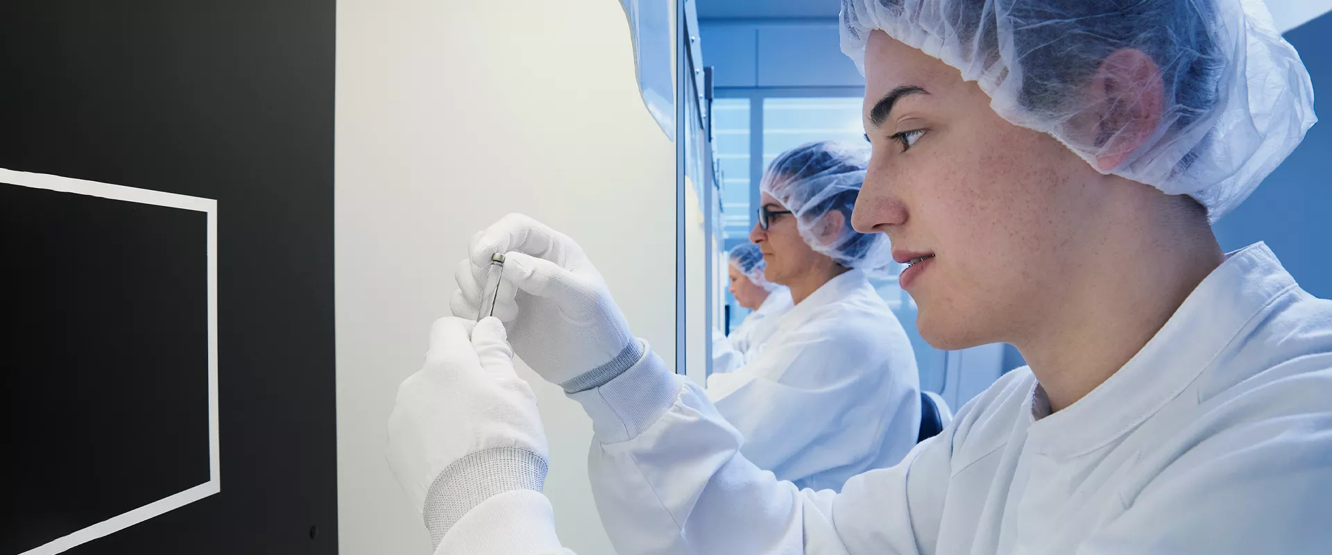 Side-ways view of scientists holding vials in a laboratory