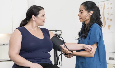doctor taking the blood pressure of her patient