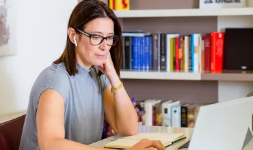 A business woman using a laptop while listening to music