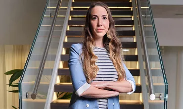 A female Director standing in-front of stairs at the Novartis office in Basel