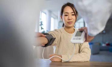 A patient having her blood pressure measured with a machine