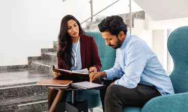 A female manager talking with her co-worker in a corporate lobby
