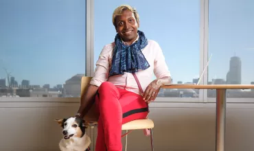 Kumar Veerapen, Senior Expert Data Science sitting with a dog in front of windows