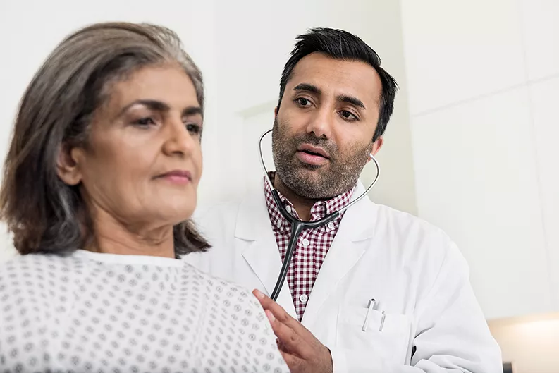 Doctor examines patient by listening to their heartbeat Doctor examines patient by listening to their heartbeat
