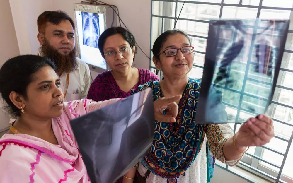 The medical team, including deputy project coordinator Dr. Kamrun Nahar (left), examines X-rays at the Kamalapur clinic. The medical team, including deputy project coordinator Dr. Kamrun Nahar (left), examines X-rays at the Kamalapur clinic.