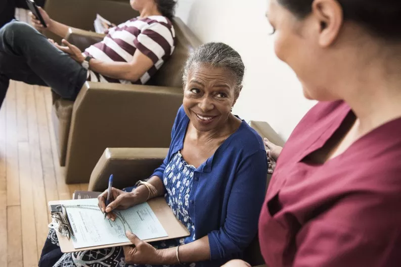Patient smiles at nurse in waiting room Patient smiles at nurse in waiting room