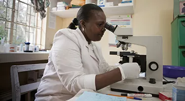 Nurse using microscope to diagnose malaria in Kenya. Nurse using microscope to diagnose malaria in Kenya.