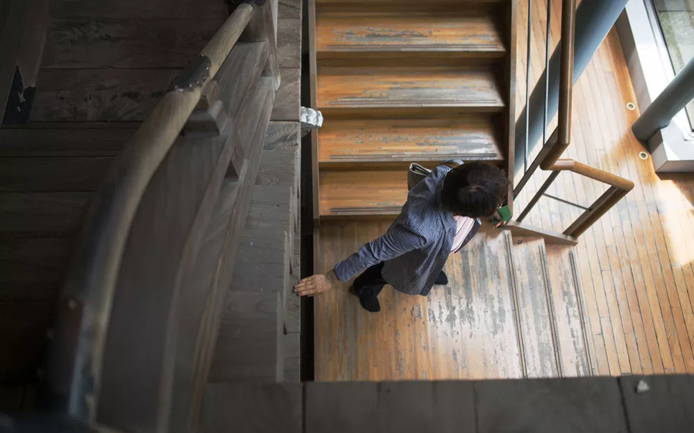 A woman visits a historic shrine in Tokyo. Ms. Yoshikawa navigating a staircase at a historic shrine.