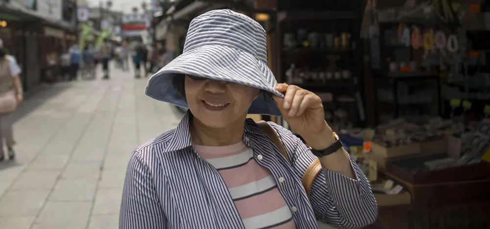 Woman with eye disease shelters her eyes from the sun. Yuko Yoshikawa has a eye disease and shelters her eyes from the sun in Tokyo.