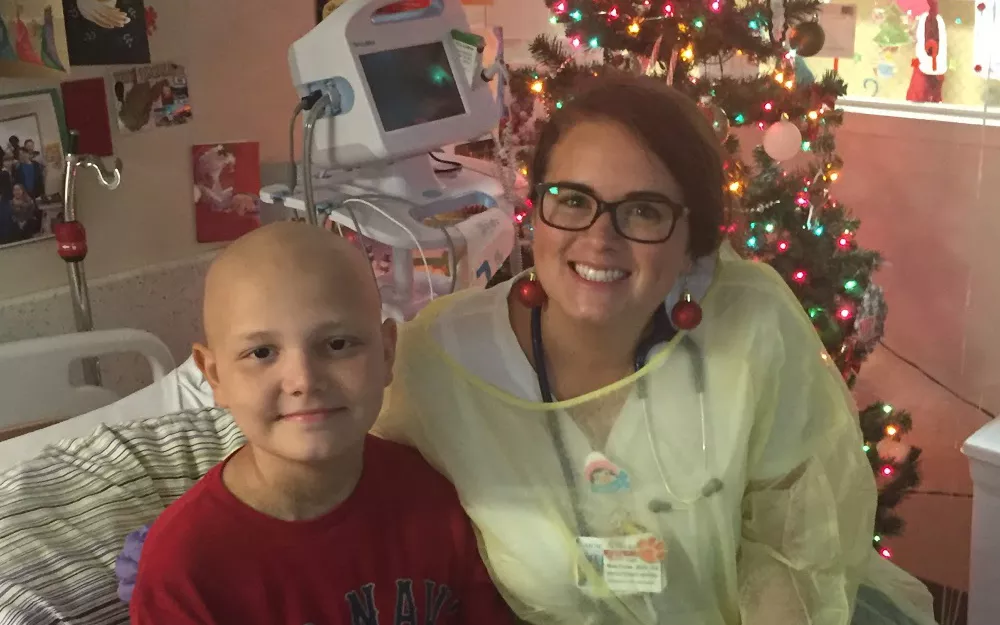 Ryan with a nurse in front of a Christmas tree during his treatment for acute lymphoblastic leukemia A childhood cancer patient with a nurse in the hospital during Christmas