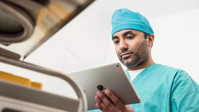 HCP with tablet Physician holding a tablet in hospital environment.