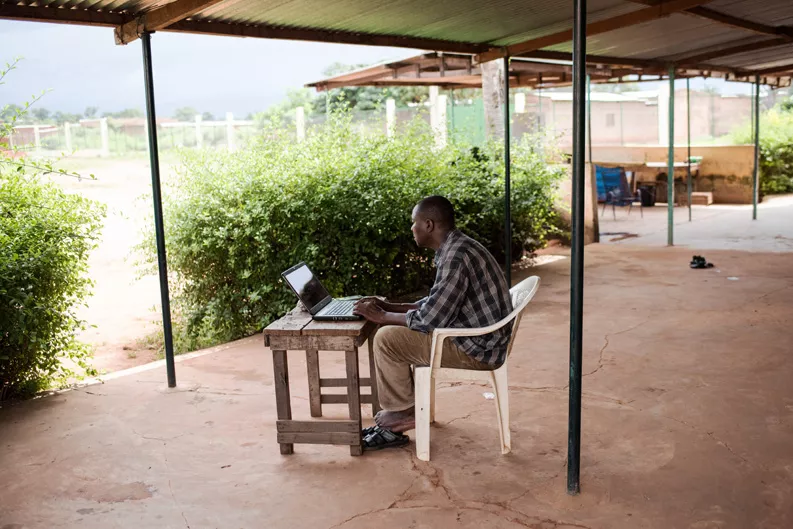 Dr. Bakary Fofana sits at a computer in Sikasso. Dr. Bakary Fofana sits at a computer in Sikasso.