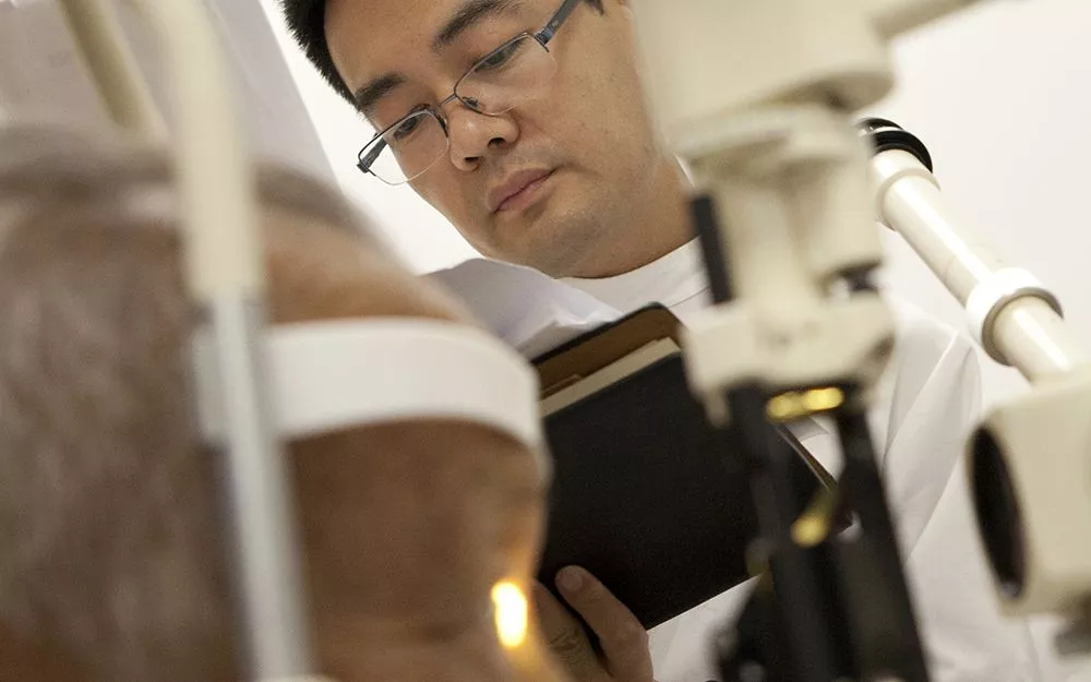 Dr. Zhang reviews his patient notes during a surgery evaluation
