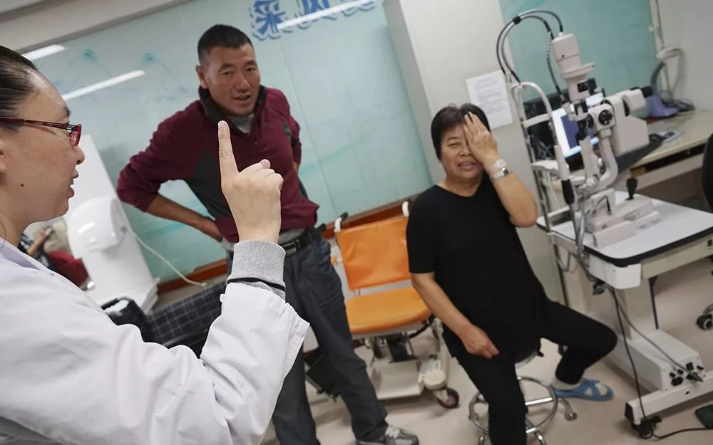 A doctor administers an eye test post-operation