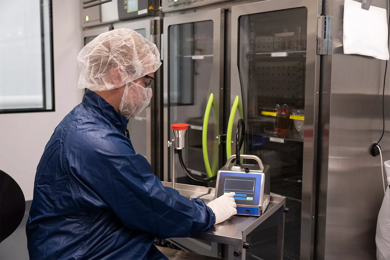 Associate in full personal protective equipment conducting quality control testing for environmental monitoring