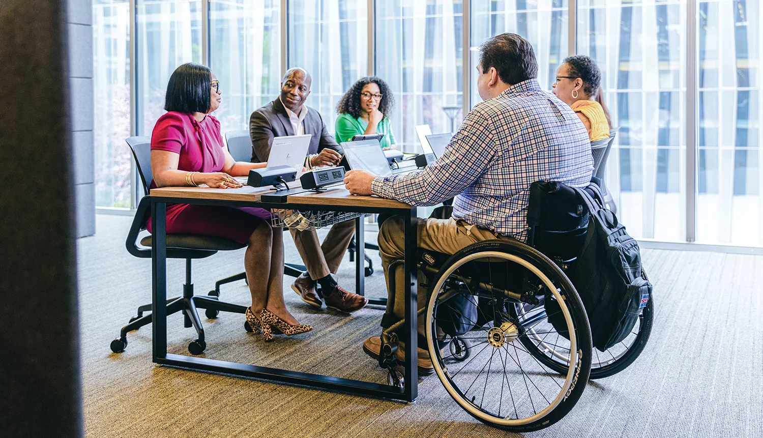 A group of people sitting around a table, in a business meeting A group of people sitting around a table, in a business meeting