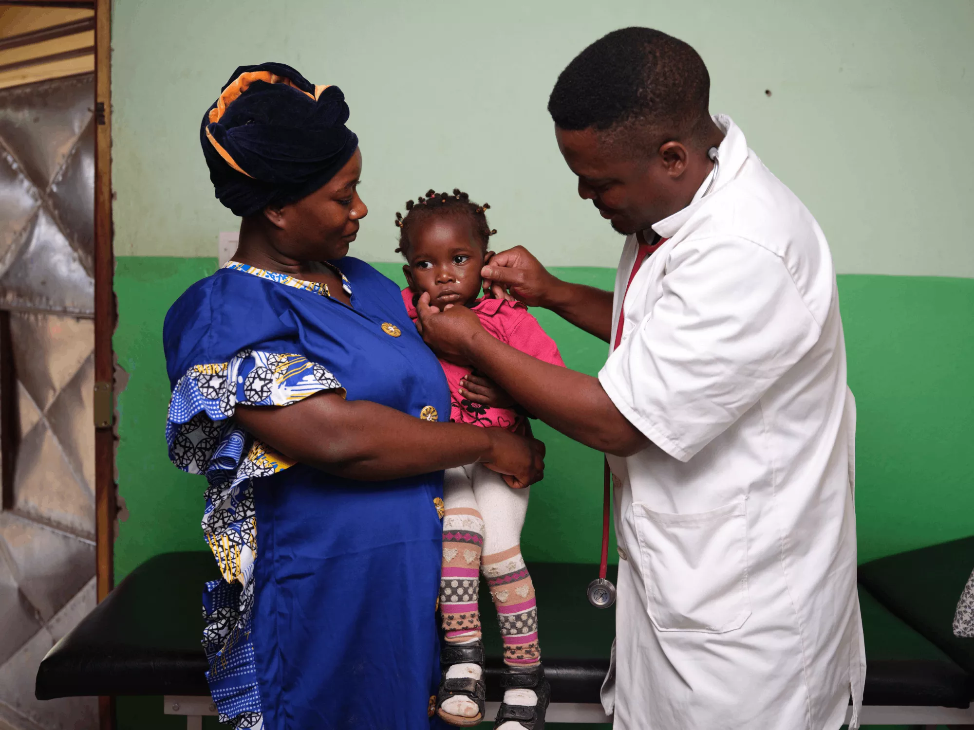 Richard Bitomo examines a child at the health center Richard Bitomo examines a child at the health center