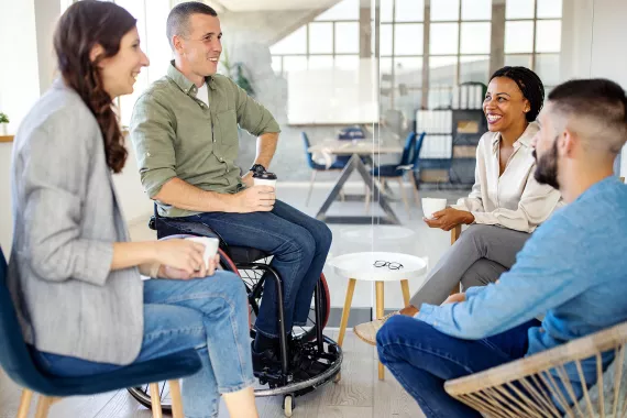 Group of four business people discussing and laughing Group of four business people discussing and laughing