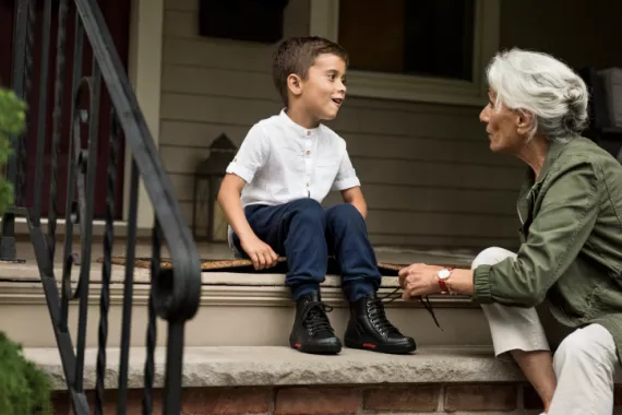 Grandmother tying her grandson's shoe laces