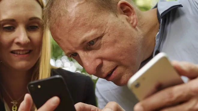 A couple showing each other data on their phones