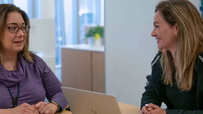 The Program lead of ‘Ensemble’ sitting with a Novartis employee and caregiver
