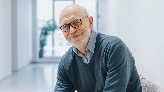 Elder man with glasses smiling