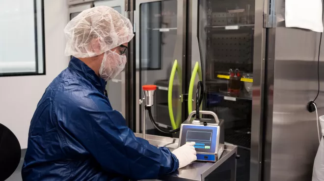 Associate in full personal protective equipment conducting quality control testing