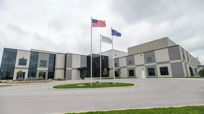 Three flags fly outside a Novartis manufacturing facility
