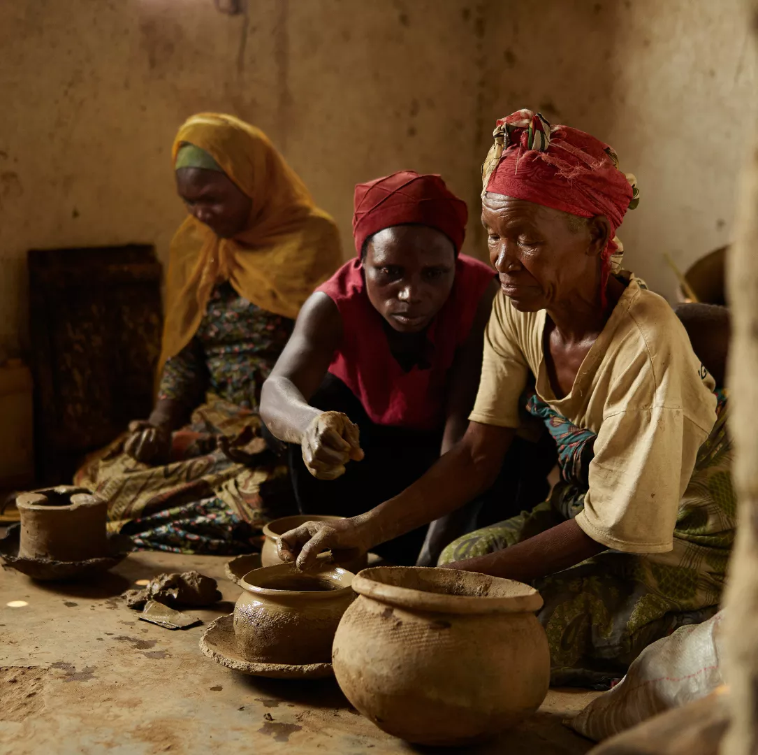 Three women making ceramic pots in Rwanda