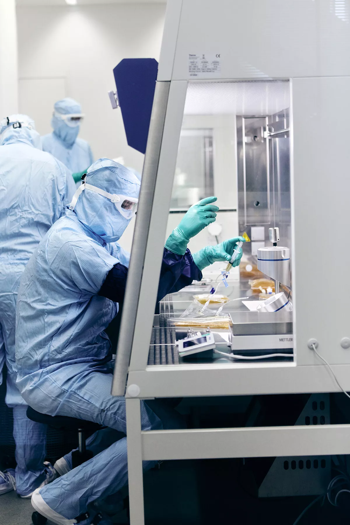 A process operator performs process operation in a biosafety cabinet A process operator performs process operation in a biosafety cabinet