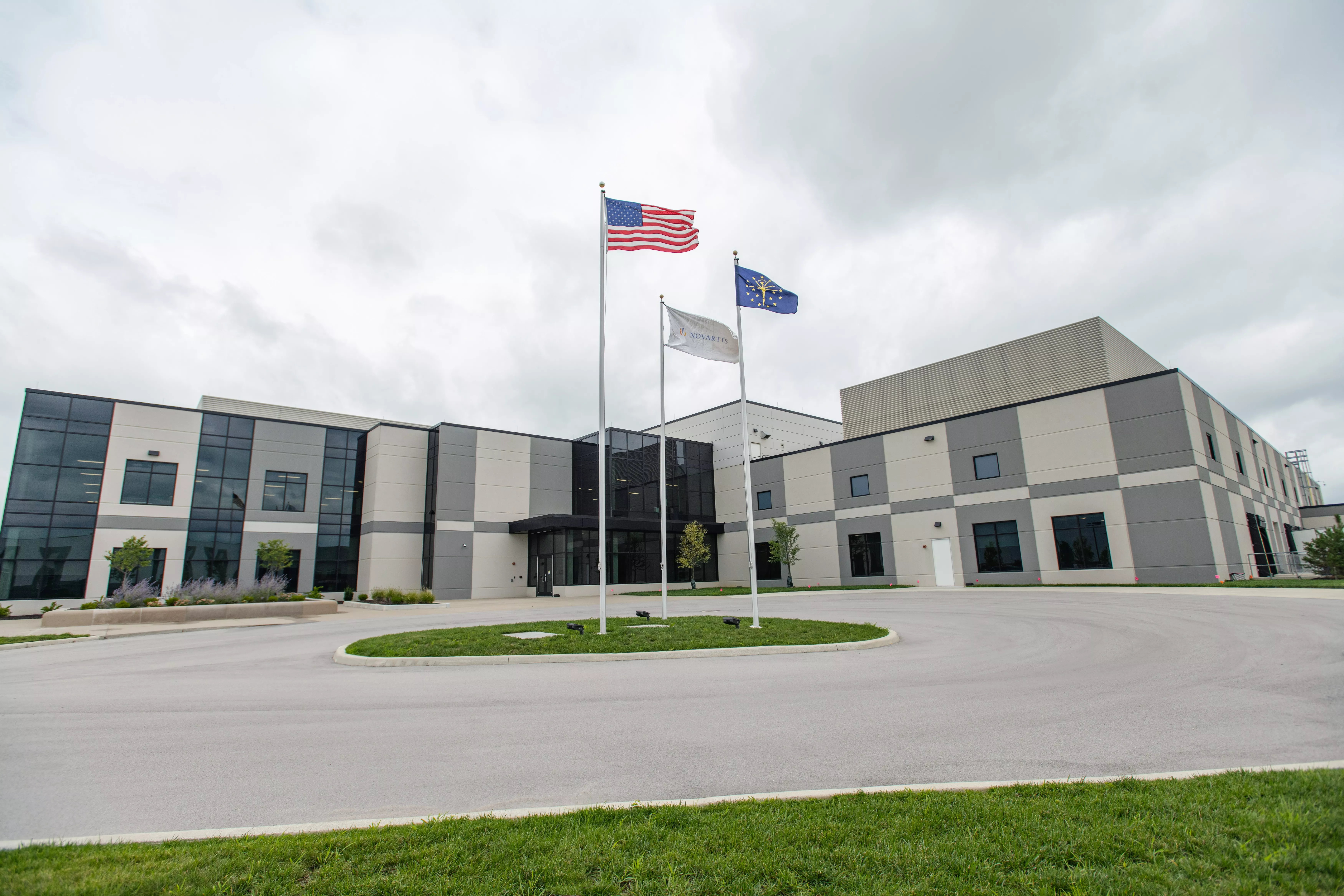 Three flags fly outside a Novartis manufacturing facility Three flags fly outside a Novartis manufacturing facility